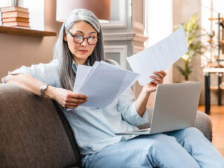 Busy attractive mature businesswoman working at home with laptop